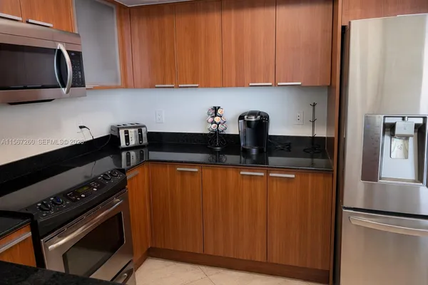 a kitchen with stainless steel appliances a stove a microwave a sink and cabinets