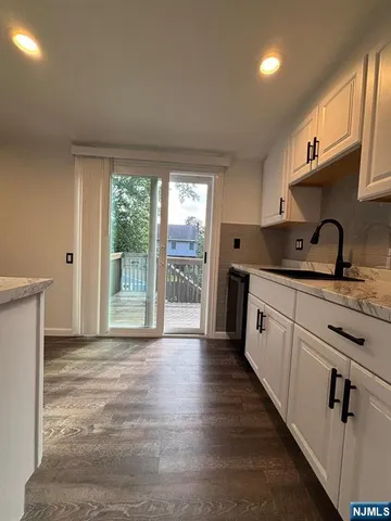 a kitchen with granite countertop a sink and a refrigerator