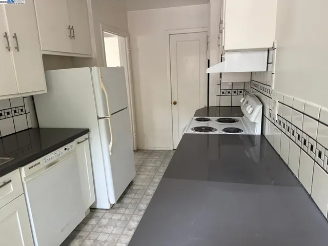 a kitchen with a refrigerator and a stove