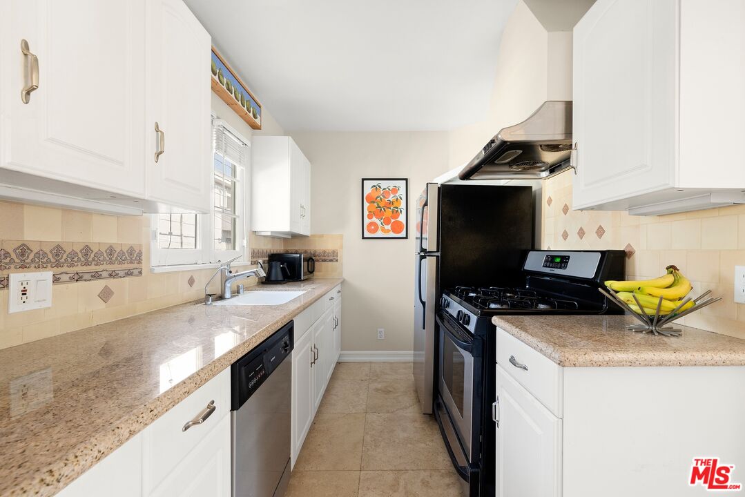827 12th Street Santa Monica, CA 90403 - Photo 13 of 15 a kitchen with stainless steel appliances granite countertop a sink stove and refrigerator