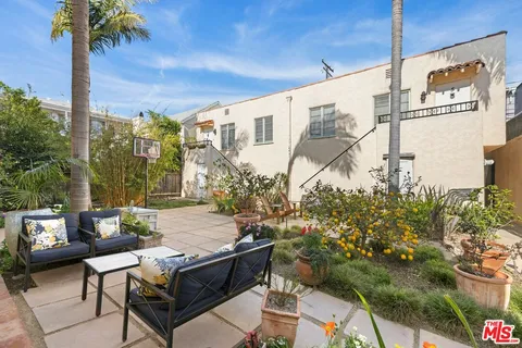 a view of a porch with chairs and potted plants
