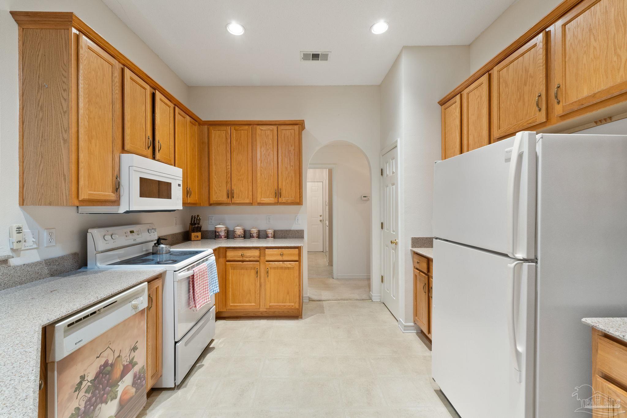 5073 Brookside Drive Pace, FL 32571 - Photo 17 of 38 a refrigerator freezer sitting in a kitchen with stainless steel appliances granite countertop cabinets and a refrigerator