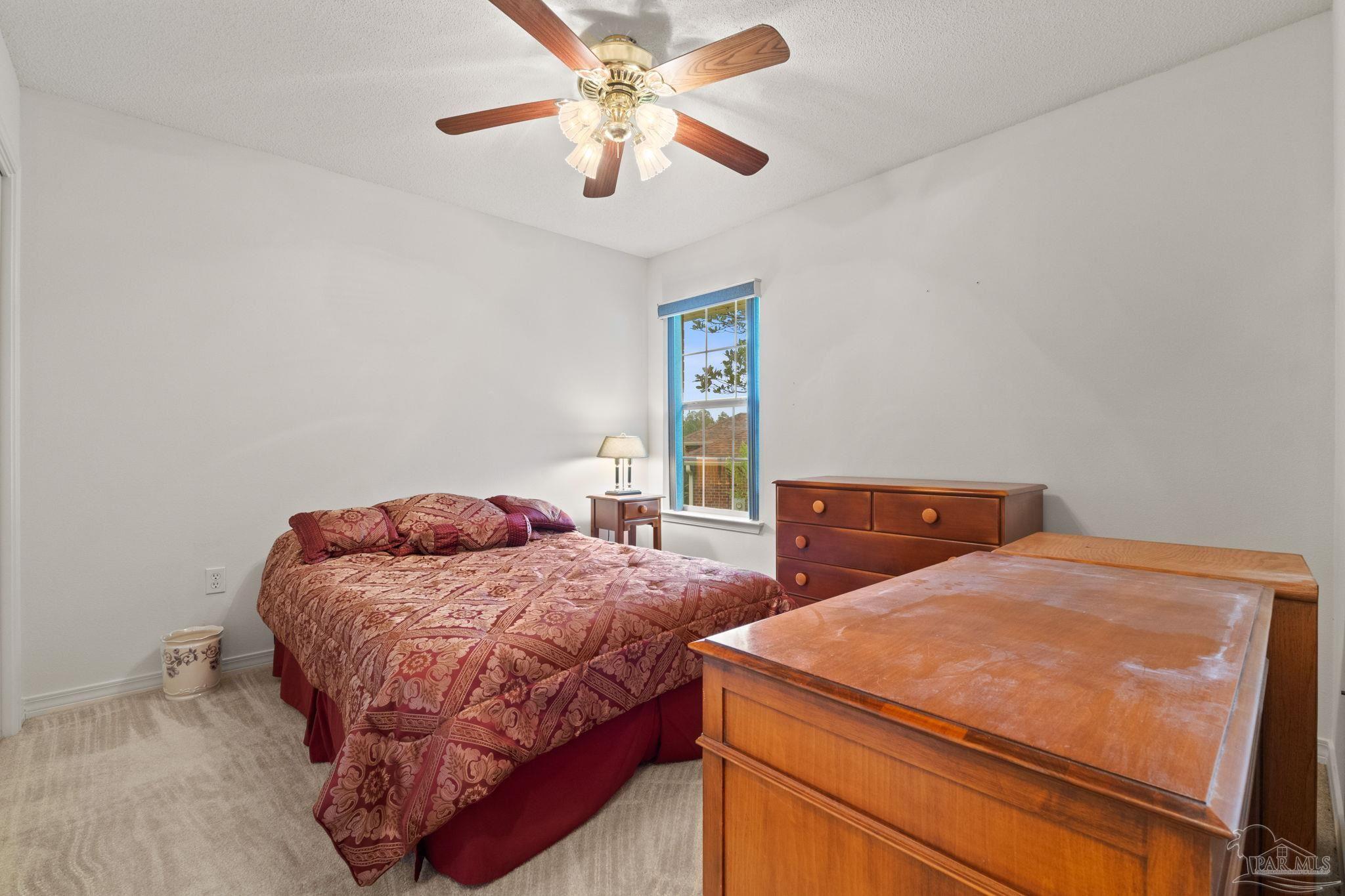 5073 Brookside Drive Pace, FL 32571 - Photo 20 of 38 a bedroom with a bed and a chandelier