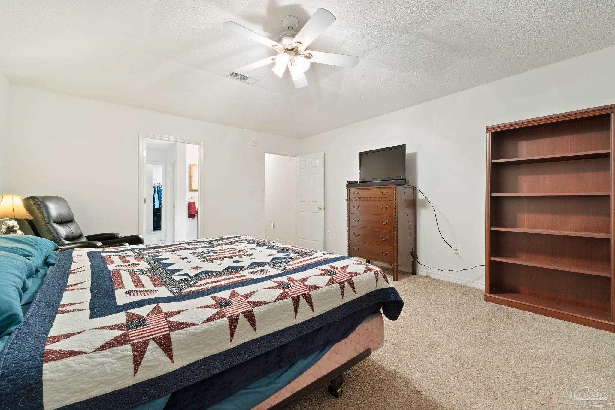 5073 Brookside Drive Pace, FL 32571 - Photo 25 of 38 a bedroom with a bed and a chandelier