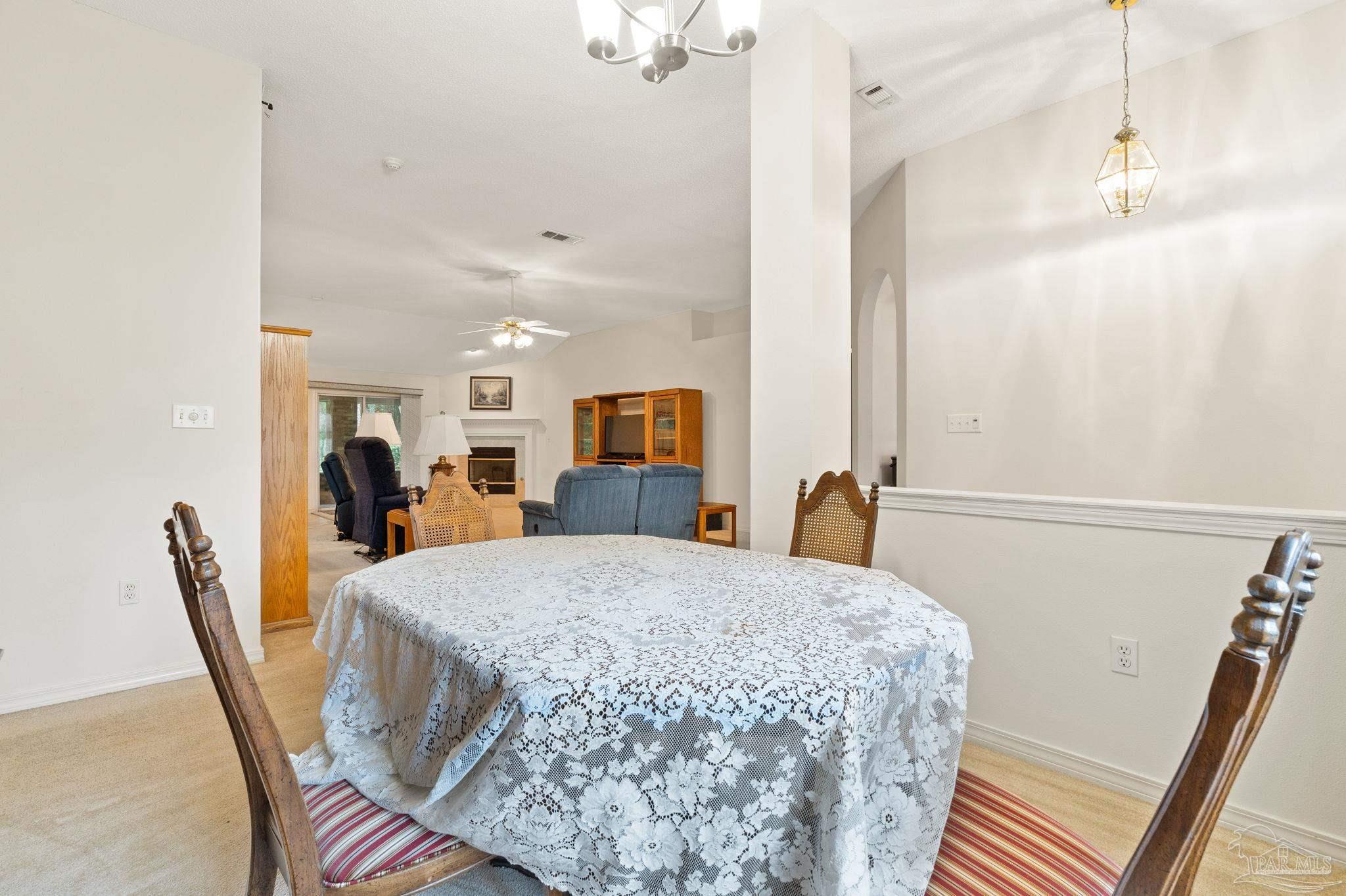 5073 Brookside Drive Pace, FL 32571 - Photo 7 of 38 a living room with furniture and a chandelier