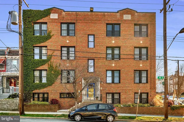 a front view of a residential apartment building with a yard