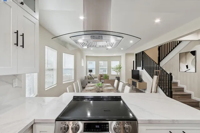 a living room with a large window and chandelier