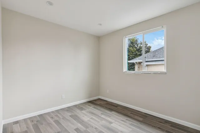 a view of an empty room with a window and a ceiling fan
