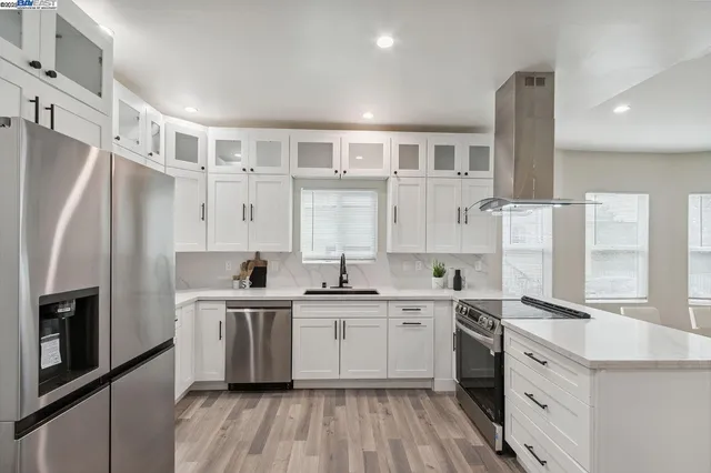 a kitchen with white cabinets stainless steel appliances and sink