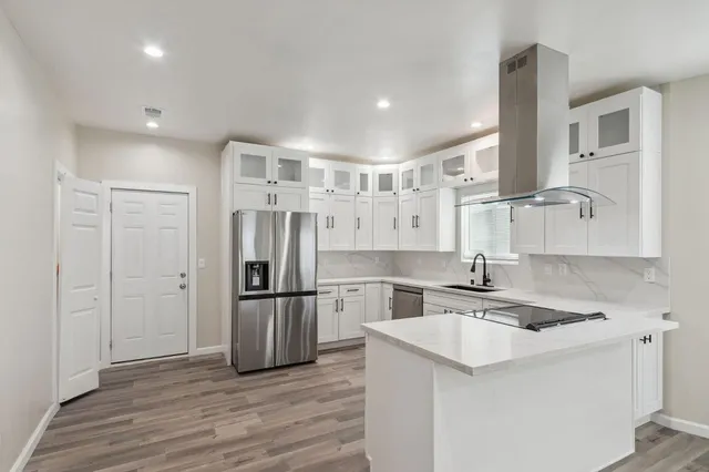 a kitchen with refrigerator cabinets and wooden floor