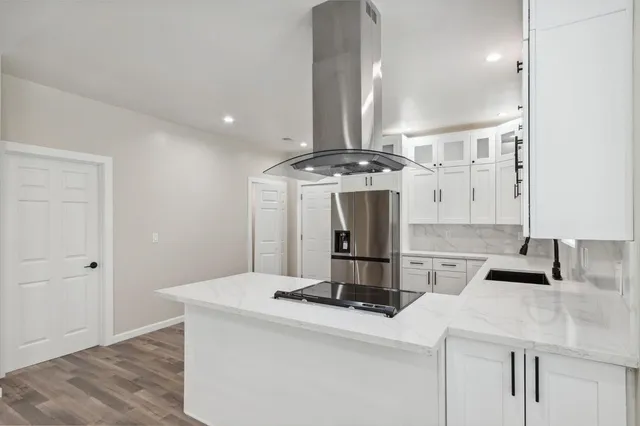 a kitchen with stainless steel appliances granite countertop a sink a stove and a refrigerator