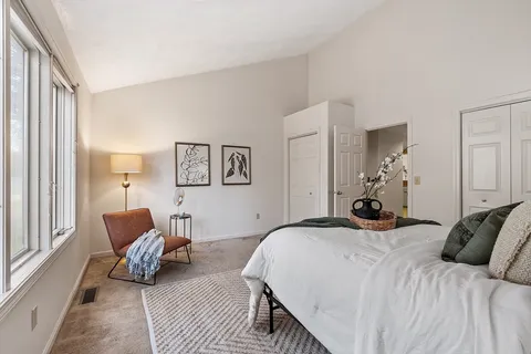 a bedroom with a bed couch and a window