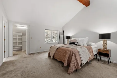 a spacious bedroom with a bed and a lamp