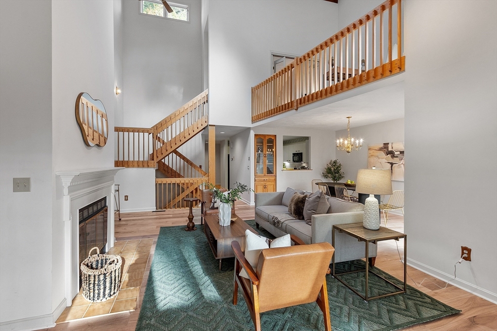 28 Monadnock Drive, Unit 28 Westford, MA 01886 - Photo 5 of 31 a living room with couches a rug and a dining table with wooden floor