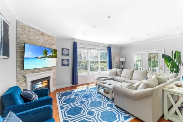 a living room with furniture a large window and a fireplace