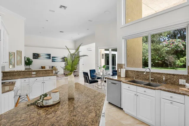 a large kitchen with granite countertop a sink and a large window