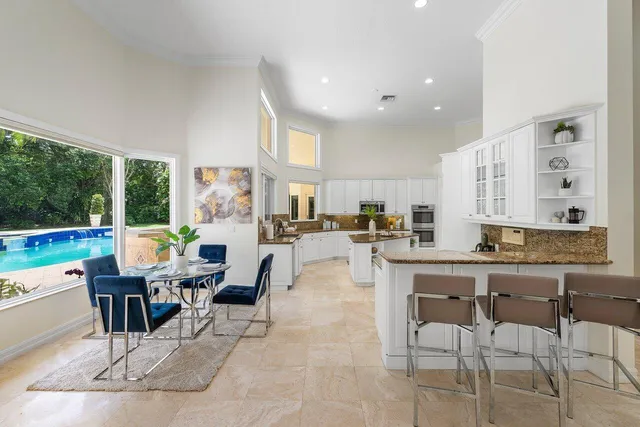 a living room with stainless steel appliances granite countertop furniture and a large window