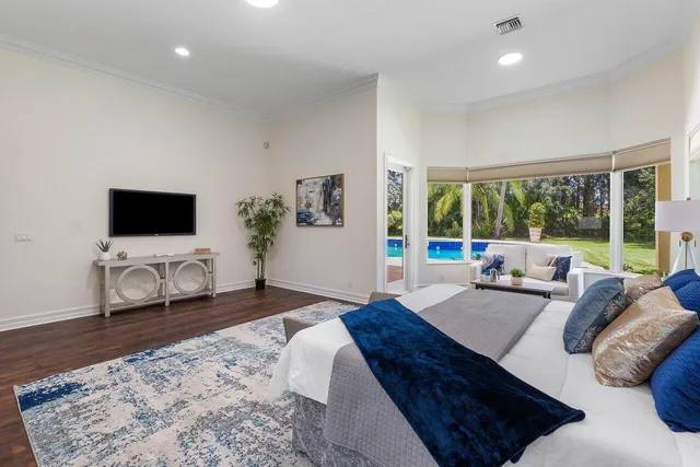 a living room with couches a flat screen tv and a balcony