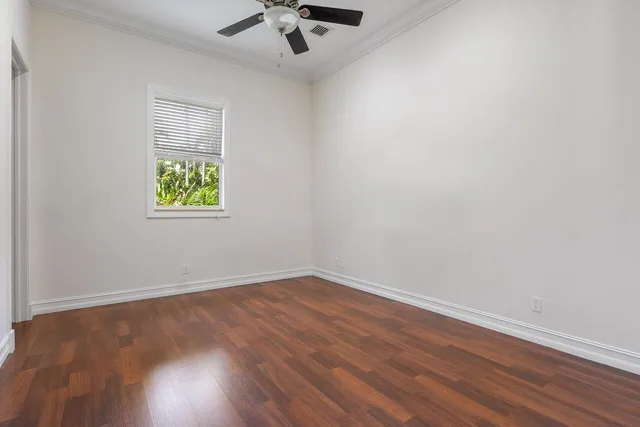 an empty room with a window and a ceiling fan