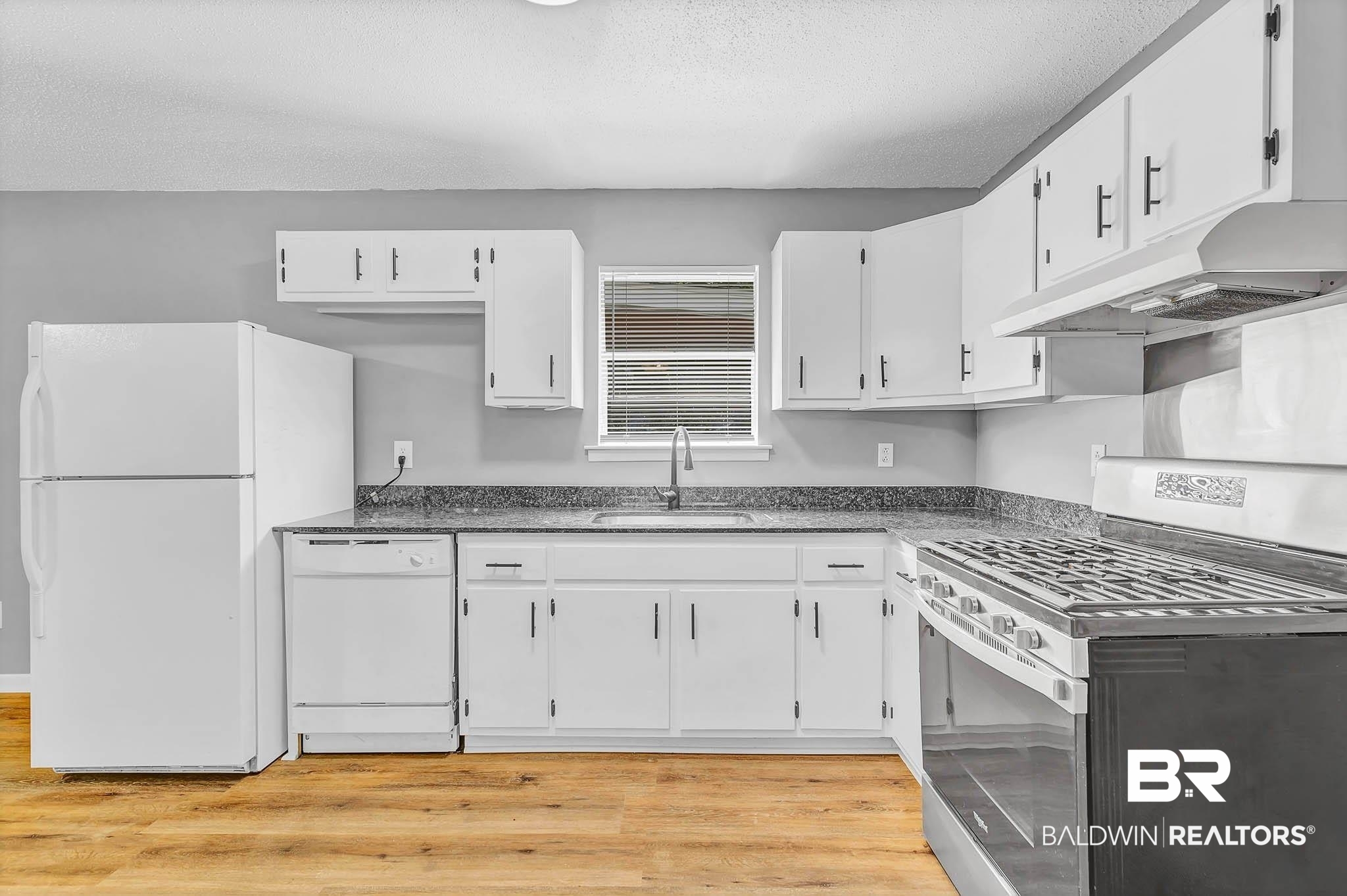 3304 Armond Drive Mobile, AL 36605 - Photo 19 of 62 Kitchen with white appliances, under cabinet range hood, white cabinets, and a textured ceiling