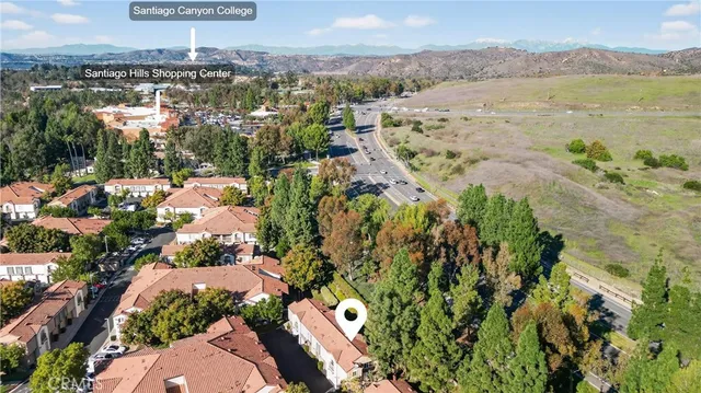 an aerial view of residential houses with outdoor space and trees