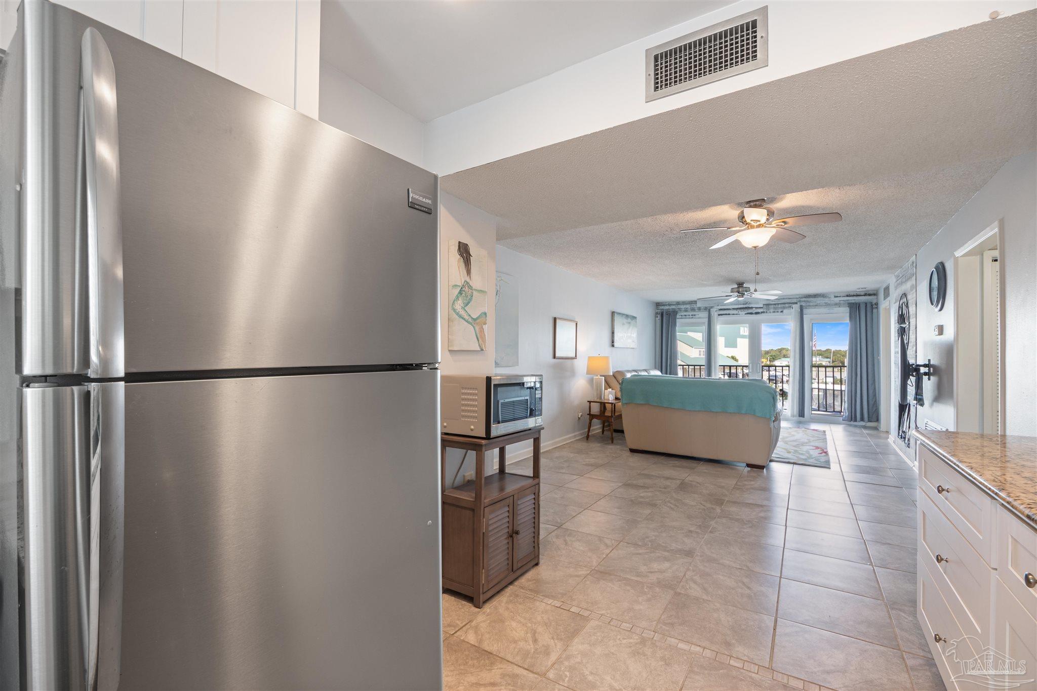 14100 River Road, Unit 228B Pensacola, FL 32507 - Photo 10 of 41 a view of a kitchen with furniture and refrigerator