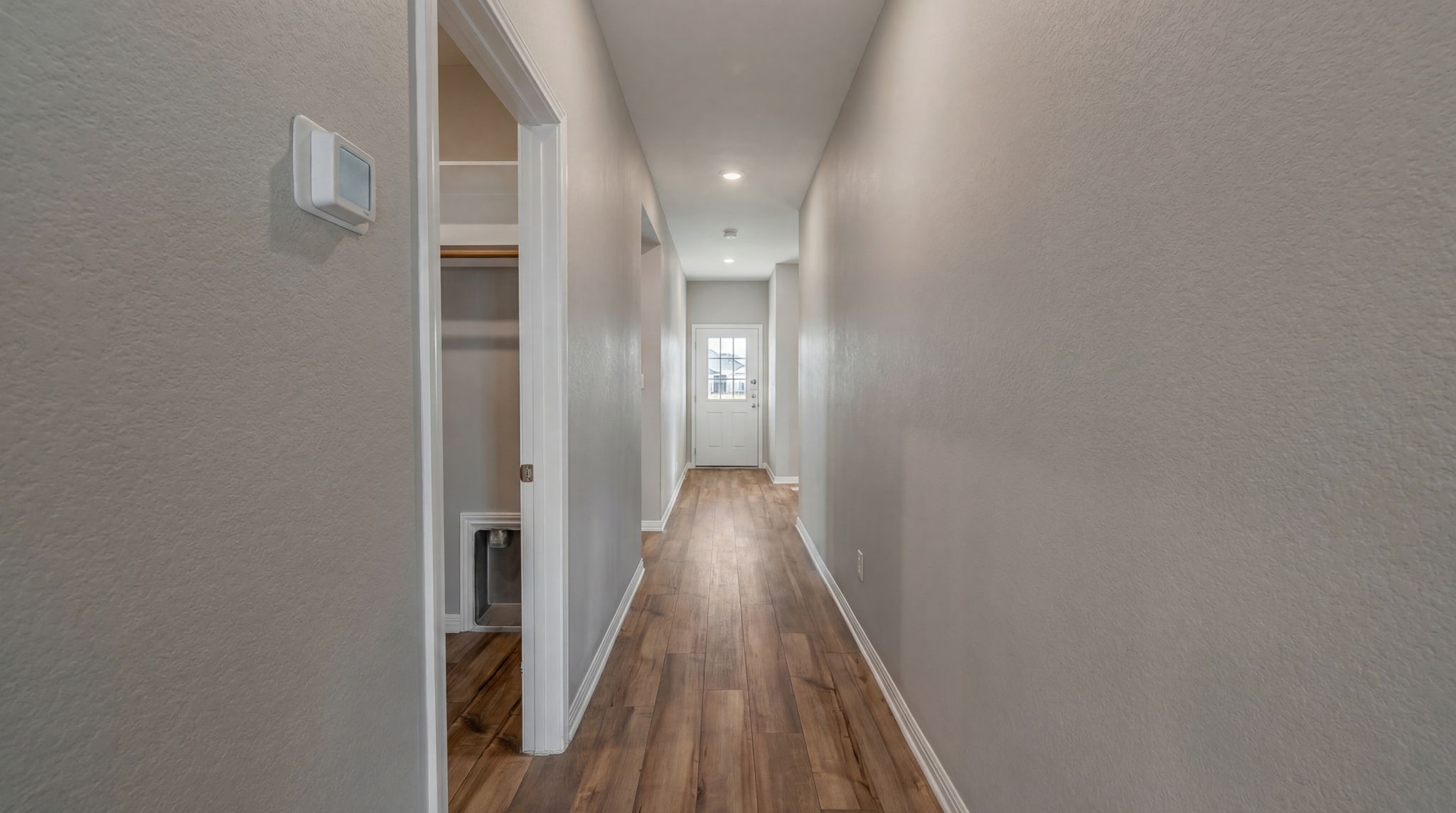 1003 Round Bale Road Hutto, TX 78634 - Photo 19 of 29 Hall featuring a textured wall, dark wood-style flooring, and recessed lighting