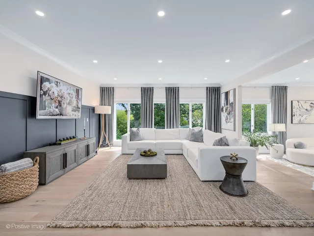 a view of a dining room and livingroom with furniture wooden floor kitchen view and chandelier