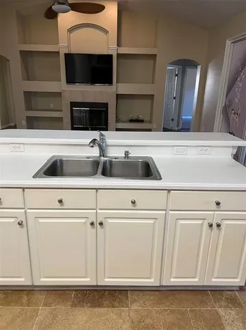 a kitchen with white cabinets and a sink
