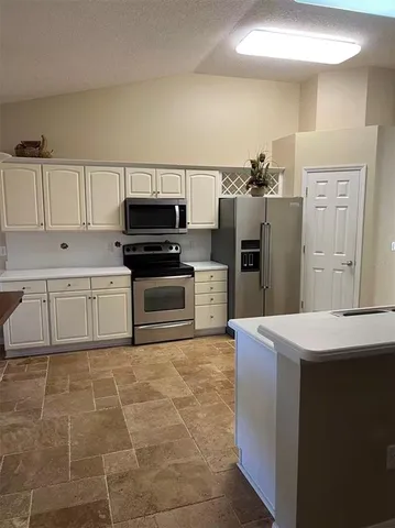 a kitchen with stainless steel appliances a refrigerator and cabinets