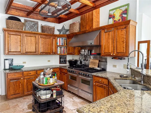 a kitchen with stainless steel appliances granite countertop a stove a sink and a microwave