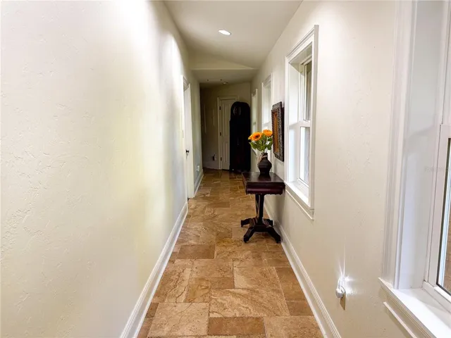 a view of a hallway with closet and a window