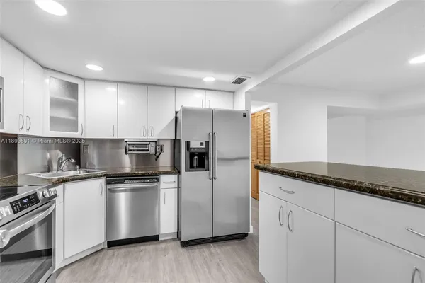 a kitchen with granite countertop cabinets and steel stainless steel appliances