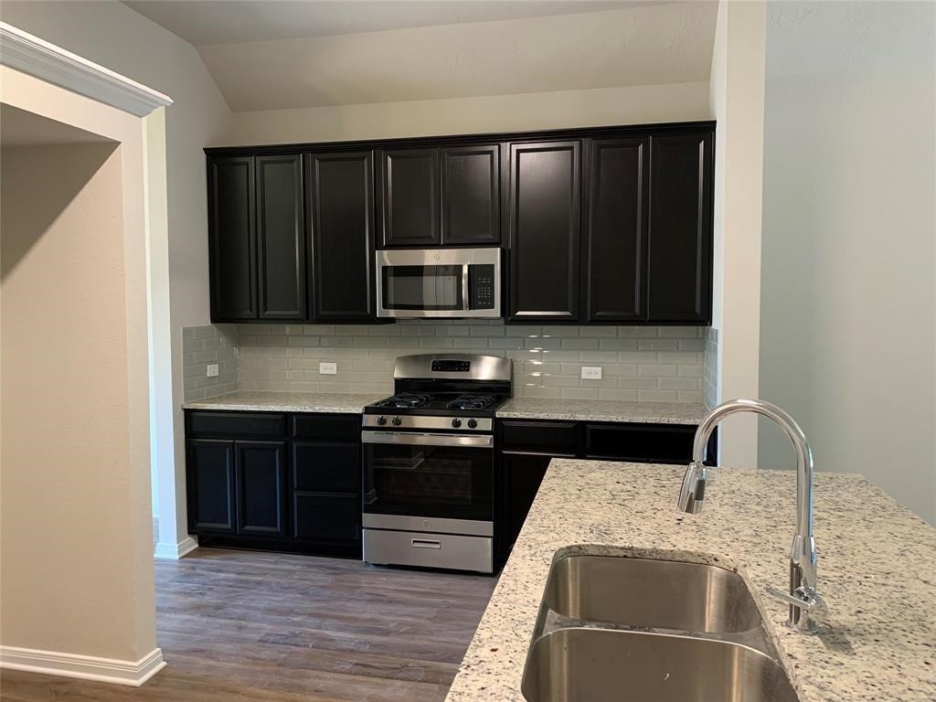 994 Arbor Crossing Conroe, TX 77303 - Photo 3 of 9 a kitchen with wooden cabinets and stainless steel appliances