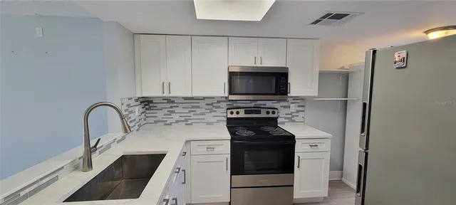 a kitchen with appliances a sink and cabinets