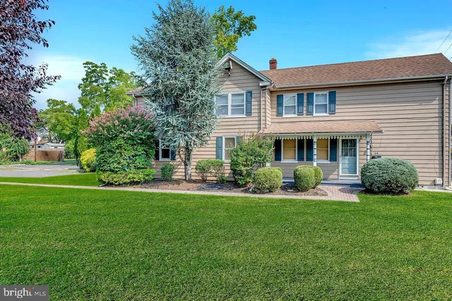 a front view of a house with a yard and trees