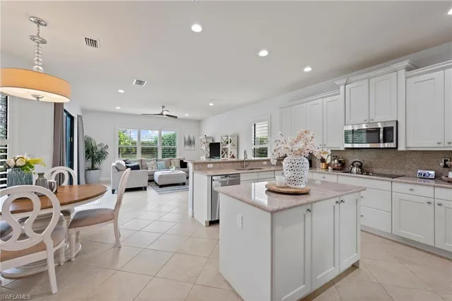 a kitchen with white cabinets a sink dishwasher stove and white cabinets with wooden floor
