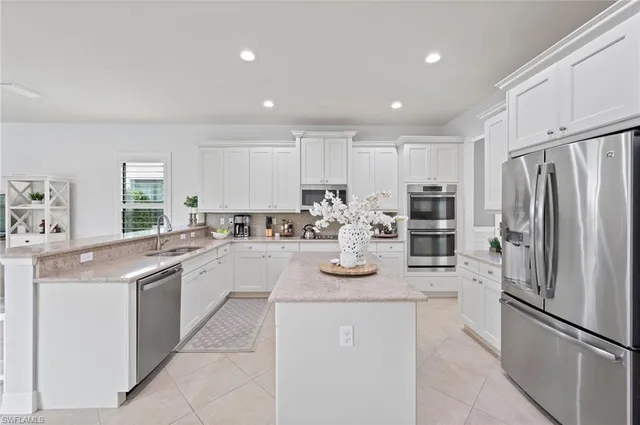 a kitchen with kitchen island white cabinets and stainless steel appliances