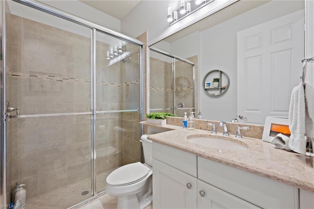 3082 Hudson Terrace Naples, FL 34119 - Photo 22 of 48 a bathroom with a granite countertop sink toilet and shower
