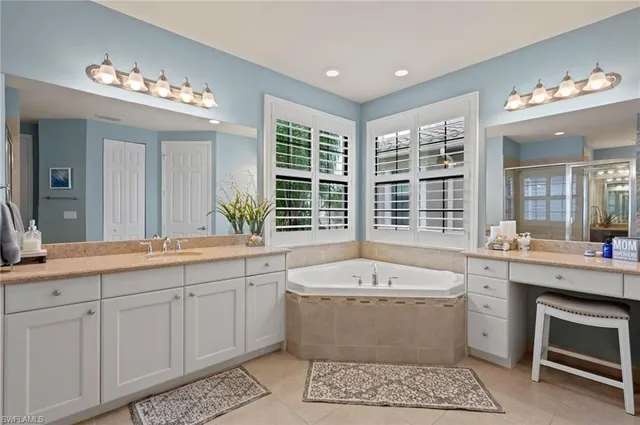 a spacious bathroom with a granite countertop sink a mirror and shower
