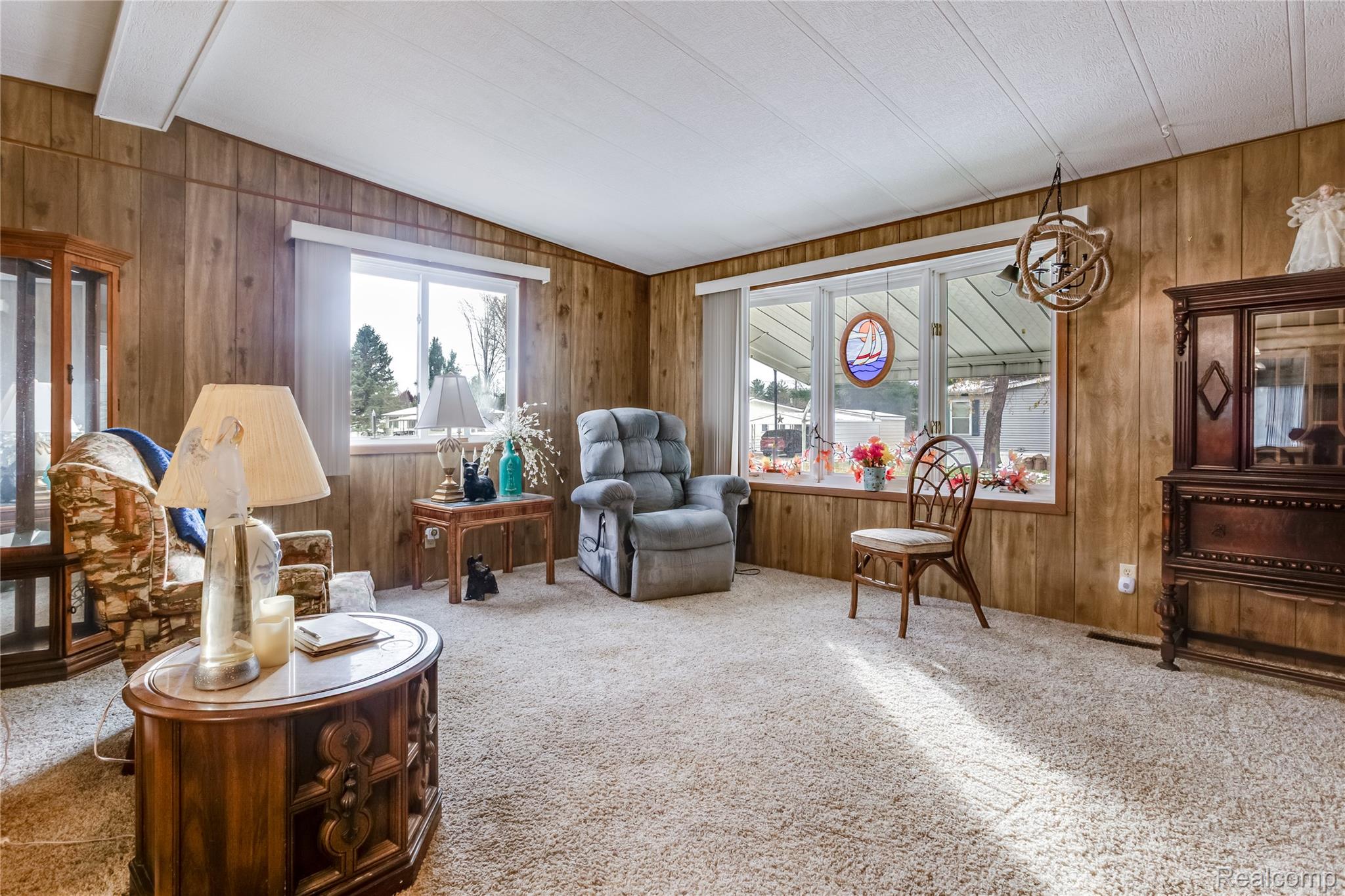 3333 Ravenswood Road Marysville, MI 48040 - Photo 8 of 25 Living area with carpet flooring, vaulted ceiling with beams, and wooden walls