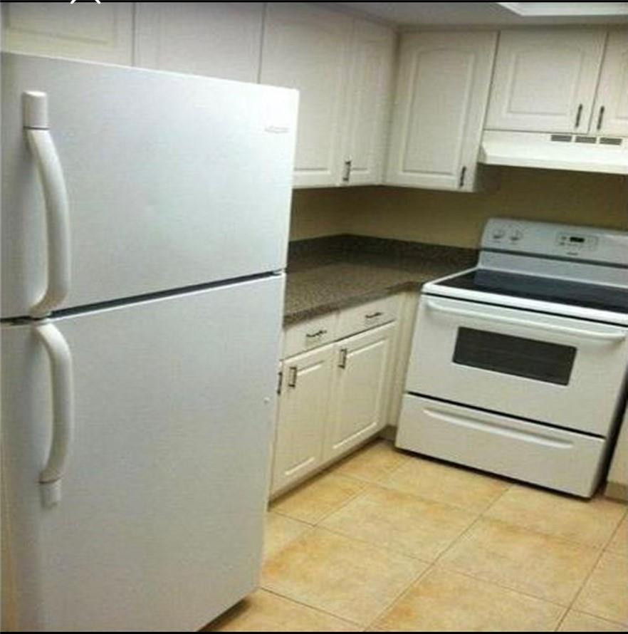 81 Deer Creek Road, Unit J103 Deerfield Beach, FL 33442 - Photo 2 of 8 a white refrigerator freezer sitting inside of a kitchen