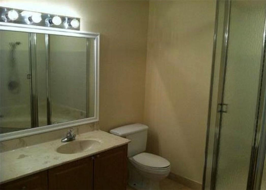 81 Deer Creek Road, Unit J103 Deerfield Beach, FL 33442 - Photo 4 of 8 a bathroom with a sink and a mirror