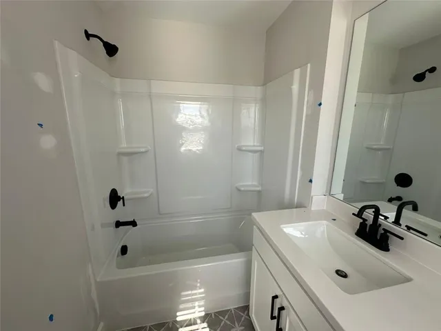 a bathroom with a bathtub sink vanity and mirror