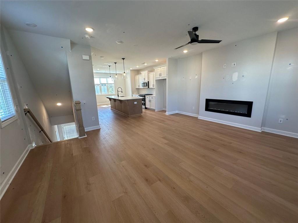 1925 Audra Alley Kennesaw, GA 30144 - Photo 19 of 24 a view of an empty room with wooden floor and a kitchen