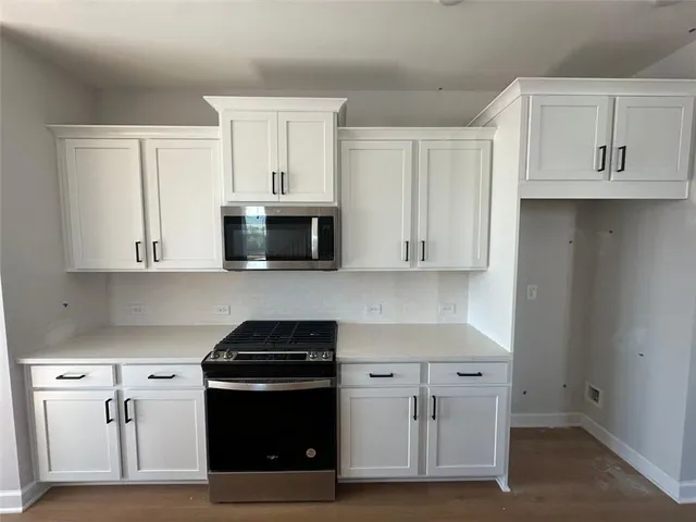 a kitchen with white cabinets and stainless steel appliances