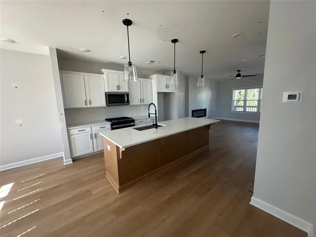 a kitchen with stainless steel appliances granite countertop a stove and a wooden floor
