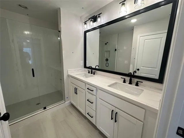 a bathroom with a double vanity sink and mirror