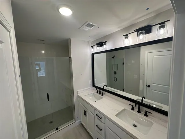 a bathroom with a double vanity sink and mirror