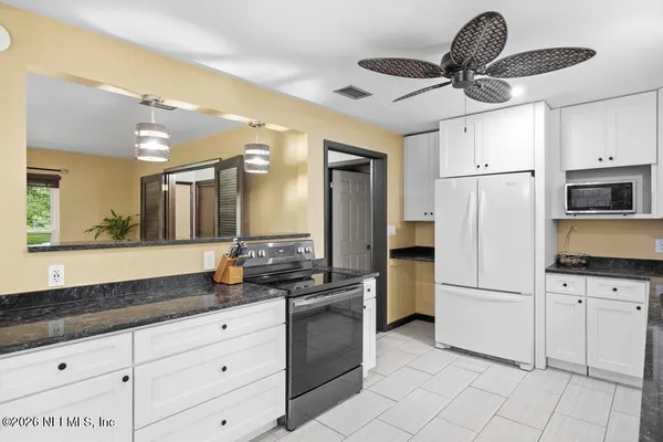 a kitchen with white cabinets and stainless steel appliances